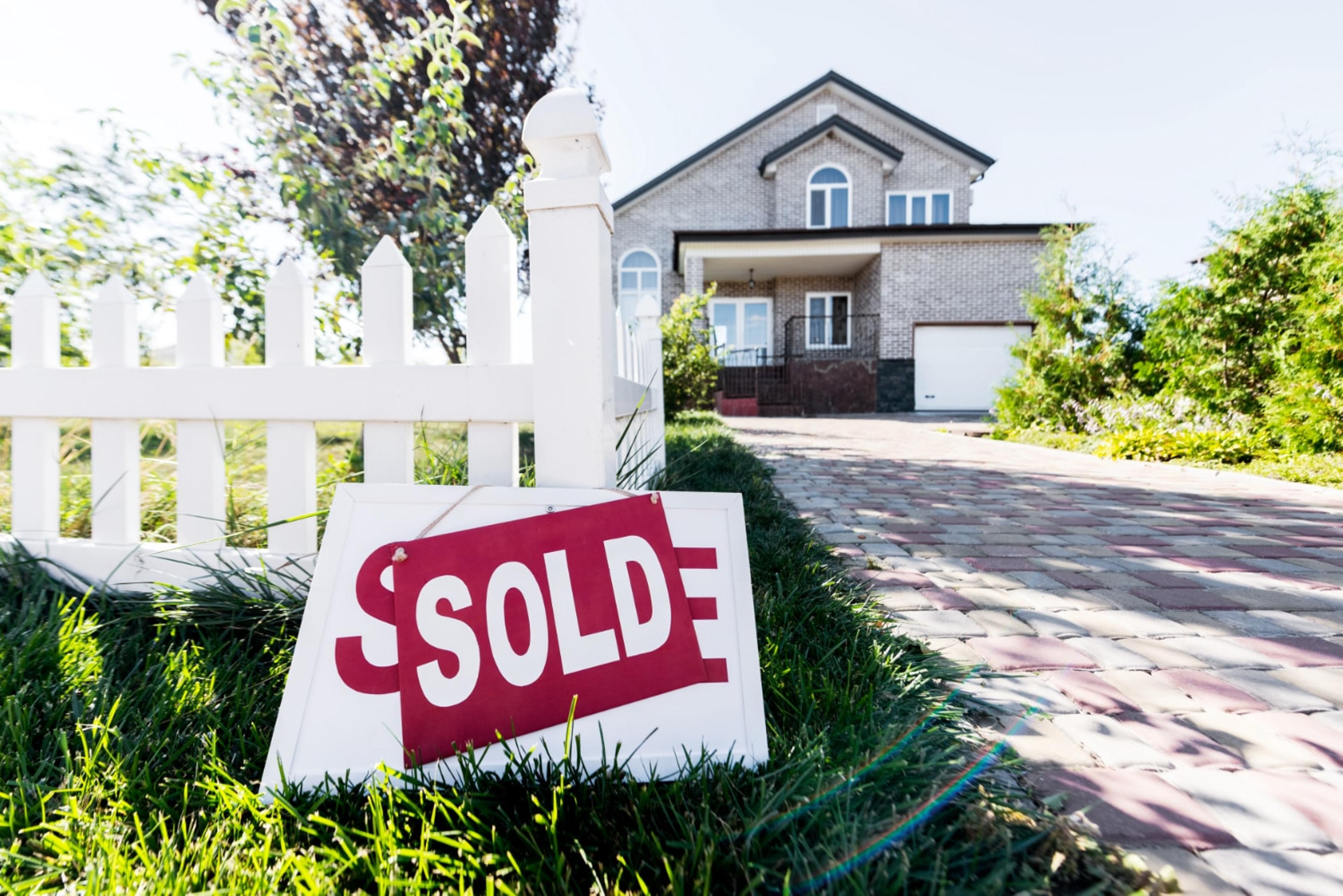 House with sold sign in front